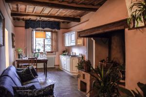 uma cozinha e sala de estar com um sofá e uma mesa em Fattoria Guicciardini em San Gimignano