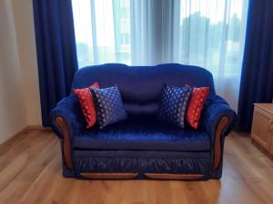 a blue couch with pillows sitting in a living room at Apartment Central Park in Daugavpils