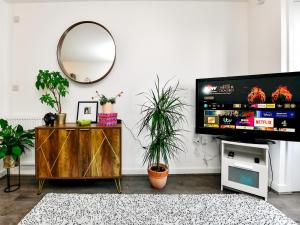a living room with a tv and a mirror at Pass the Keys Cosy 2 Bedroom Apartment in Barry with Parking in Barry