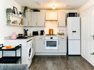 a kitchen with white cabinets and a white refrigerator at Pass the Keys Cosy 2 Bedroom Apartment in Barry with Parking in Barry
