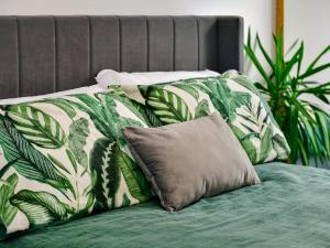 een bed met groene en witte dekens en kussens bij Pass the Keys Cosy 2 Bedroom Apartment in Barry with Parking in Barry