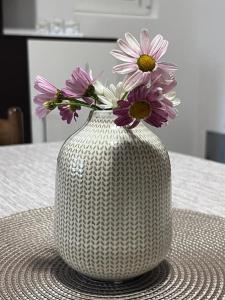 um vaso branco com flores sobre uma mesa em Apartman Kamenari em Kamenari