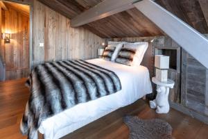 ペイゼ・ナンクロワにあるMasara - 5-room chalet plus sauna and jacuzzi 12 pの木製の部屋に大型ベッドが備わるベッドルーム1室が備わります。