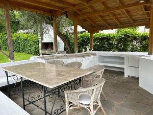 a patio with a table and chairs under a pavilion at Zeusplace Seaside Home private beach and parking in Plaka Litochorou