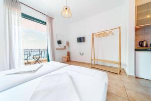 a bedroom with a bed and a view of the ocean at Giannatos Studios- Isabella in Póros Kefalonias