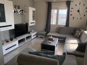 a living room with a couch and a tv at Sea View House in Kavála