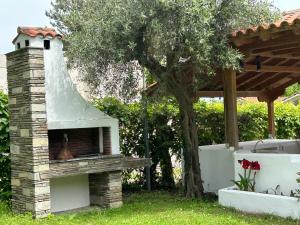 a brick oven in a yard with a tree at Zeusplace Seaside Home private beach and parking in Plaka Litochorou