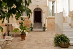 a corridor of a building with potted plants at Distilia Dimora Salentina in San Cesario di Lecce