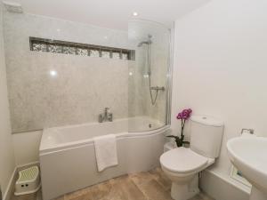 a bathroom with a tub and a toilet and a sink at Brimley Barn in Wellington +10 photos