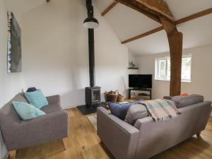 uma sala de estar com dois sofás e uma lareira em Brimley Barn em Wellington