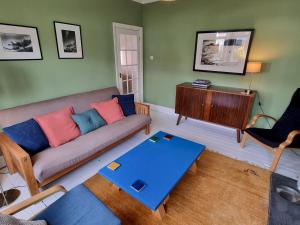 ein Wohnzimmer mit einem Sofa und einem Tisch in der Unterkunft Pass the Keys Cheerful 2 bed home with garden near Exeter centre in Exeter