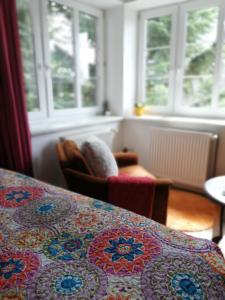 a room with windows and a table with a quilt at Dame vam pokoj - 4 pokoje se sdilenou kuchyni, kapacita max 9 osob in Harrachov