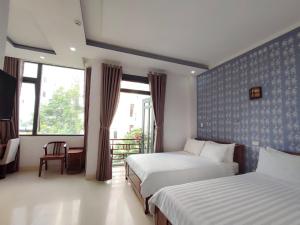 ein Hotelzimmer mit 2 Betten und einem Fenster in der Unterkunft Thanh Hiền HB Hotel in Đà Nẵng