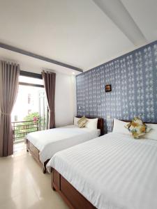 1 Schlafzimmer mit 2 Betten und einem Fenster in der Unterkunft Thanh Hiền HB Hotel in Đà Nẵng