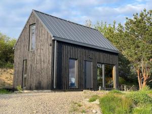 a wooden house with a black roof at Bies i Czadek in Zahoczewie