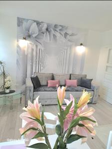 salon z kanapą i kwiatami na ścianie w obiekcie Apartment Marina 2 w Kotorze