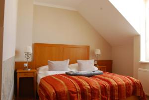 ein Schlafzimmer mit einem Bett mit einem Kissen darauf in der Unterkunft Winzerhotel Gumpoldskirchen in Gumpoldskirchen