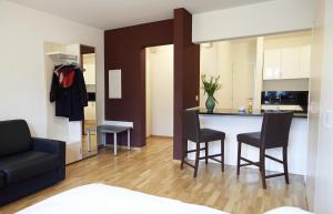 een keuken en een woonkamer met een tafel en stoelen bij Residence Apartments by Hotel du Commerce in Bazel
