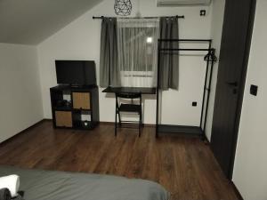 a bedroom with a bed and a television in a room at Sobe Tamaris in Slapno