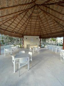 un groupe de tables et de chaises sous un toit de paille dans l'établissement Zamna Tulum 2BR w/Pool & Wifi, à Tulum