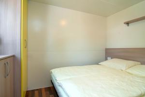 a small bedroom with a bed and a closet at Ideal Camping Lampele GmbH in Ossiach
