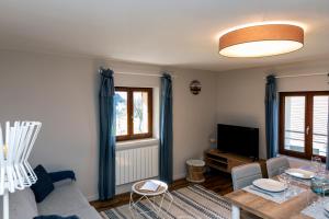 uma sala de estar com um sofá e uma mesa em T2 Meublé de 40m2 axe Annecy/Geneve em Saint-Martin-Bellevue