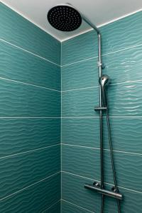 y baño con ducha y azulejos azules. en T2 Meublé de 40m2 axe Annecy/Geneve, en Saint-Martin-Bellevue
