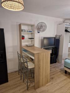 a living room with a table and chairs and a tv at Le Topaze Studio in Saint-Pierre