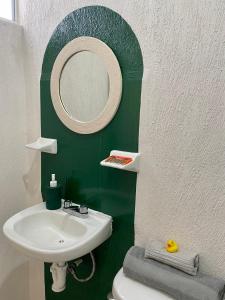 a green bathroom with a sink and a mirror at Zamna Tulum 2BR w/Pool & Wifi in Tulum