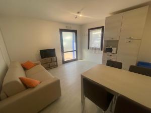 una sala de estar con un sofá y una mesa en Casa del Marinaio - Agenzia Cocal, en Caorle