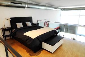 1 dormitorio con 1 cama en blanco y negro en Fantástico Loft de Diseño en Alcalá de Henares - Madrid, en Alcalá de Henares