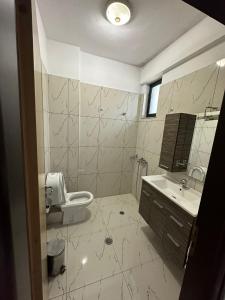 a bathroom with a toilet and a sink at Grand Park Hotel in Gjirokastër