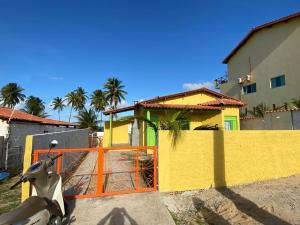 a statue of a cow in front of a yellow building at Chalé Lagoa do Pau in Coruripe
