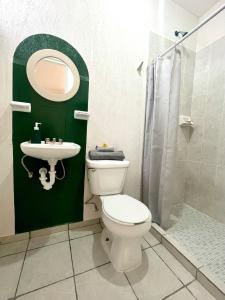 La salle de bains est pourvue de toilettes, d'un lavabo et d'un miroir. dans l'établissement Zamna Tulum 2BR w/Pool & Wifi, à Tulum