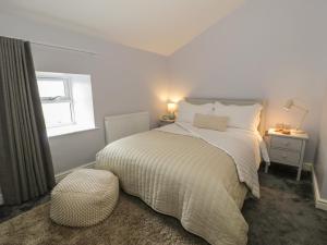 サンヴァイルプスグィンガスにある2 Bryn Gofの白いベッドルーム(ベッド1台、窓付)