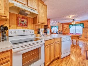 a kitchen with white appliances and wooden cabinets at Hawks Point Lodge, 5 Bedrooms, Sleeps 10, Pool Access, Hot Tub, Pool Table in Sevierville
