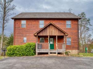 a wooden house with a green door in front at Hawks Point Lodge, 5 Bedrooms, Sleeps 10, Pool Access, Hot Tub, Pool Table in Sevierville