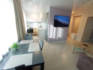 a living room with a table and a kitchen at Comfortable apartment in center in Narva