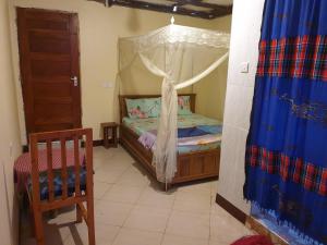 a small bedroom with a bed with a canopy at Zion Care Homestay in Arusha