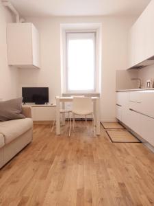 een witte woonkamer met een tafel en een keuken bij Apartment Ca' de Bezzi in Bolzano