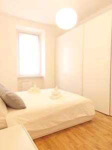 ein weißes Schlafzimmer mit einem großen Bett und einem Fenster in der Unterkunft Apartment Ca' de Bezzi in Bozen