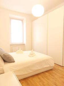 a white bedroom with a large bed and a window at Apartment Ca' de Bezzi in Bolzano