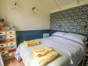 a bedroom with a bed with two towels on it at Mucklewick Hollow in Shrewsbury