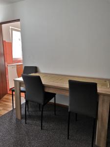uma mesa de madeira com 2 cadeiras e uma mesa com um espelho em Cittadel next door Apartment em Alba Iulia
