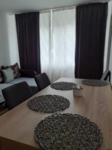 dois pratos numa mesa de madeira numa sala de estar em Cittadel next door Apartment em Alba Iulia