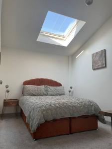 um quarto com uma cama e uma clarabóia em Smithy Bungalow, free private parking included, Buxton em Buxton