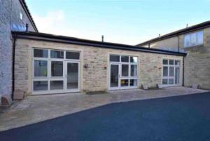 a brick house with white doors and a driveway at Smithy Bungalow, free private parking included, Buxton in Buxton