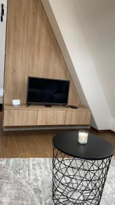 - un salon avec une table et une télévision dans l'établissement Apartman Borovi 15 Divčibare, à Divčibare