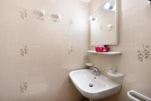 a white bathroom with a sink and a mirror at Monolocale 9 in Borgio Verezzi +13 photos