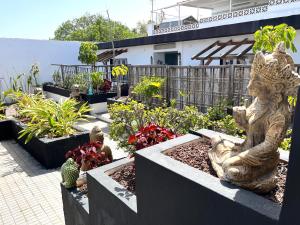 um jardim com algumas plantas e uma estátua nele em Acogedor estudio en la laguna em San Cristóbal de La Laguna